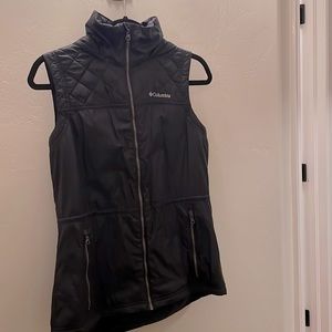 Columbia sportswear sleeveless puffer vest with hood, zips up.